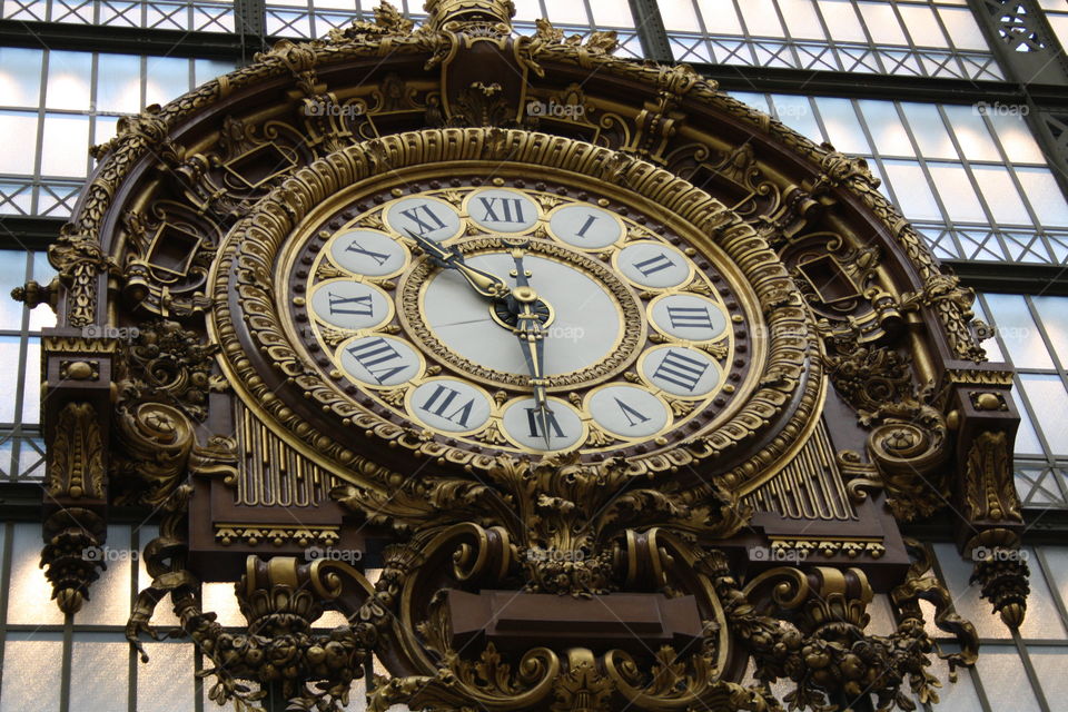 Large gilded clock in a former railroad station from Paris