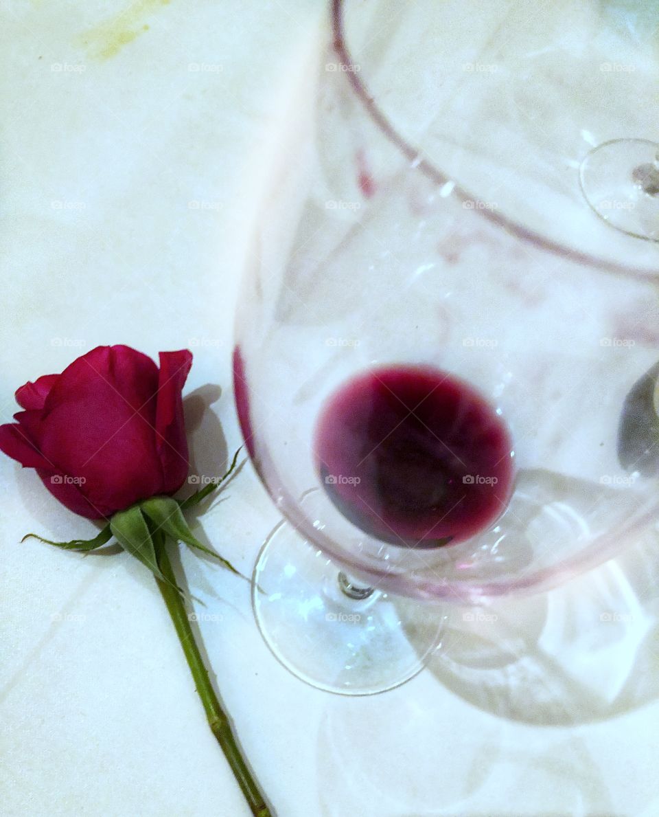 Single stem rose and empty wine glass