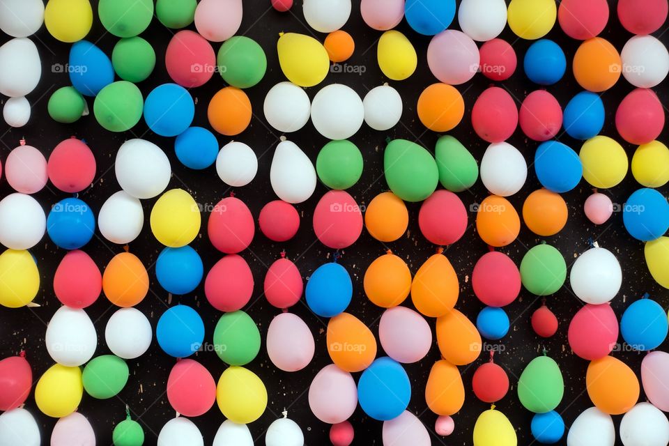 Colorful ballons hanging on black wall