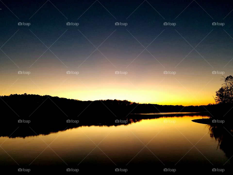 sunset on a calm lake; silhouette of island