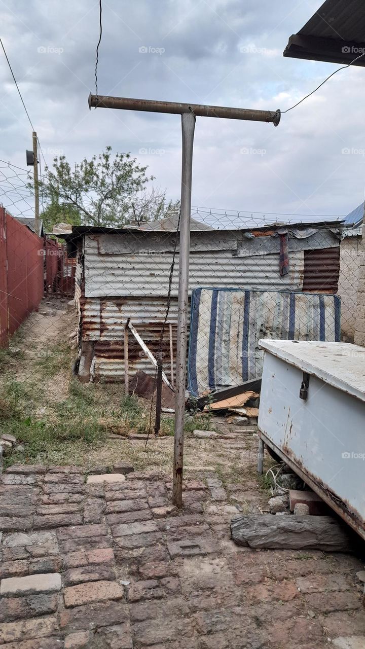 Tin shack with an old mattress outside