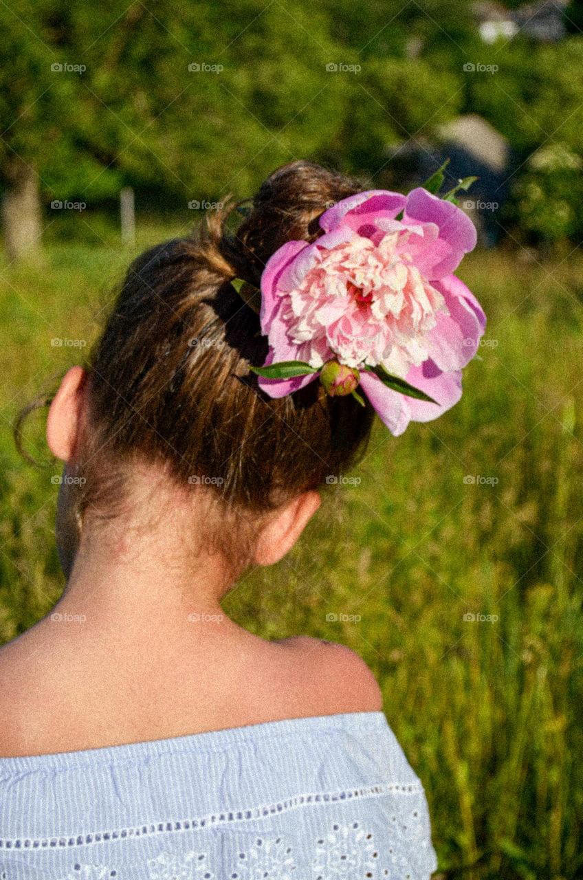 A flower as a decoration on a young lady's hairstyle
