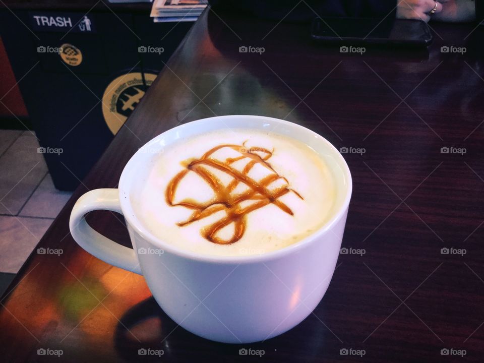 Cappuccino with caramel drizzled on top of foam