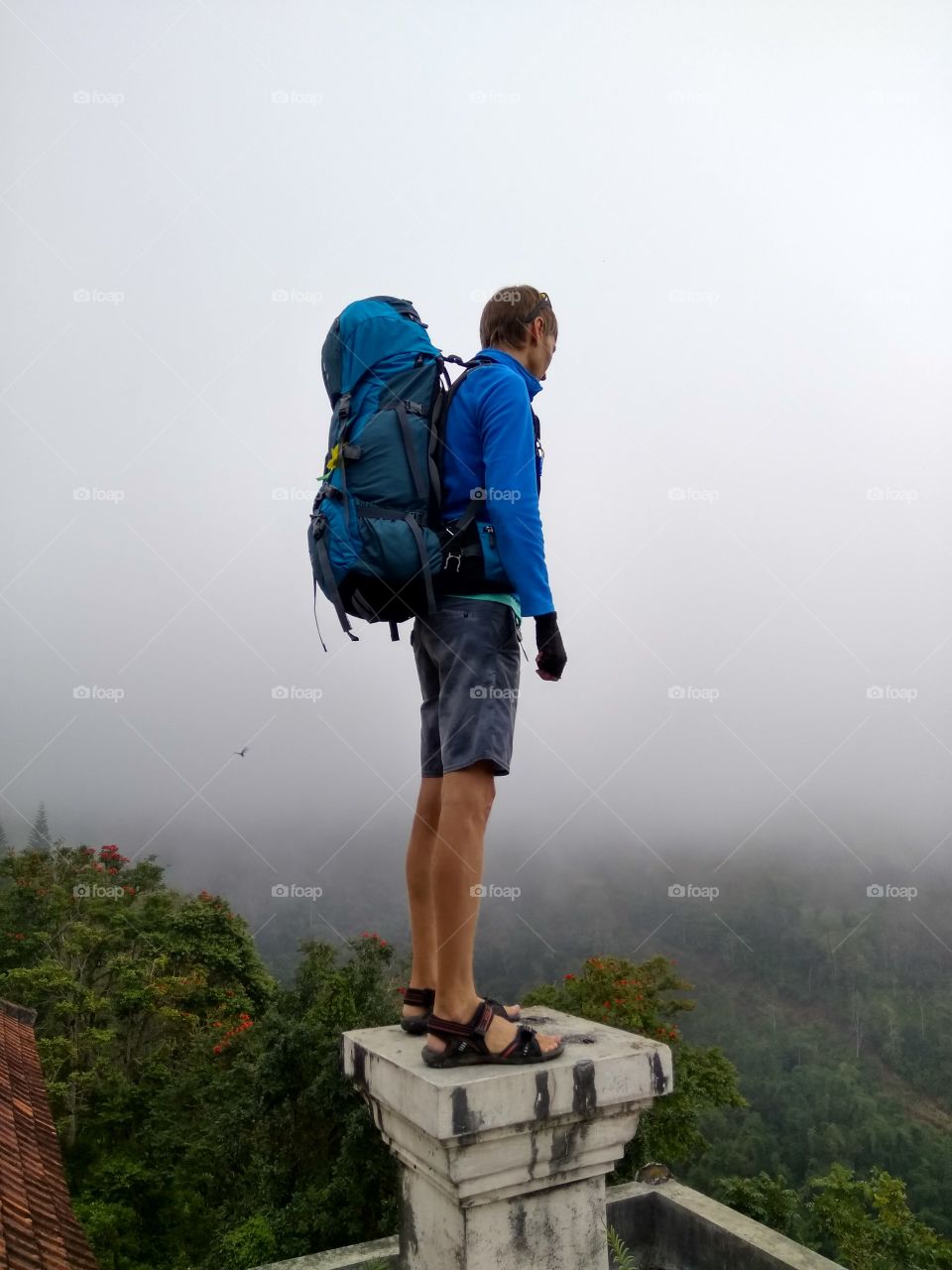 man with backpack standing on the top