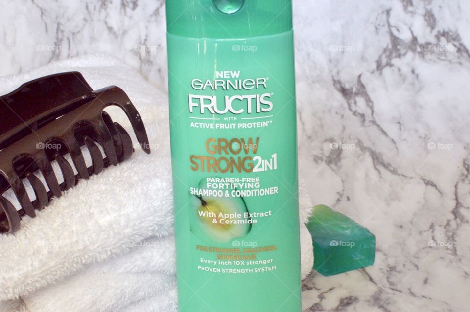 Garnier grow strong two and one conditioner and shampoo on a marble backdrop