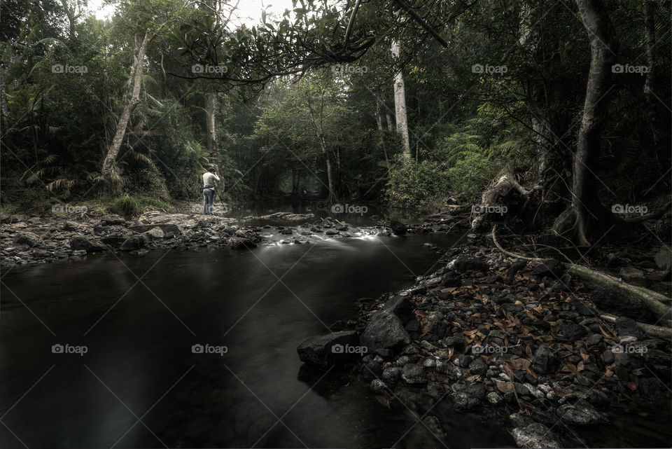 Photographer taking a picture in the forest pond