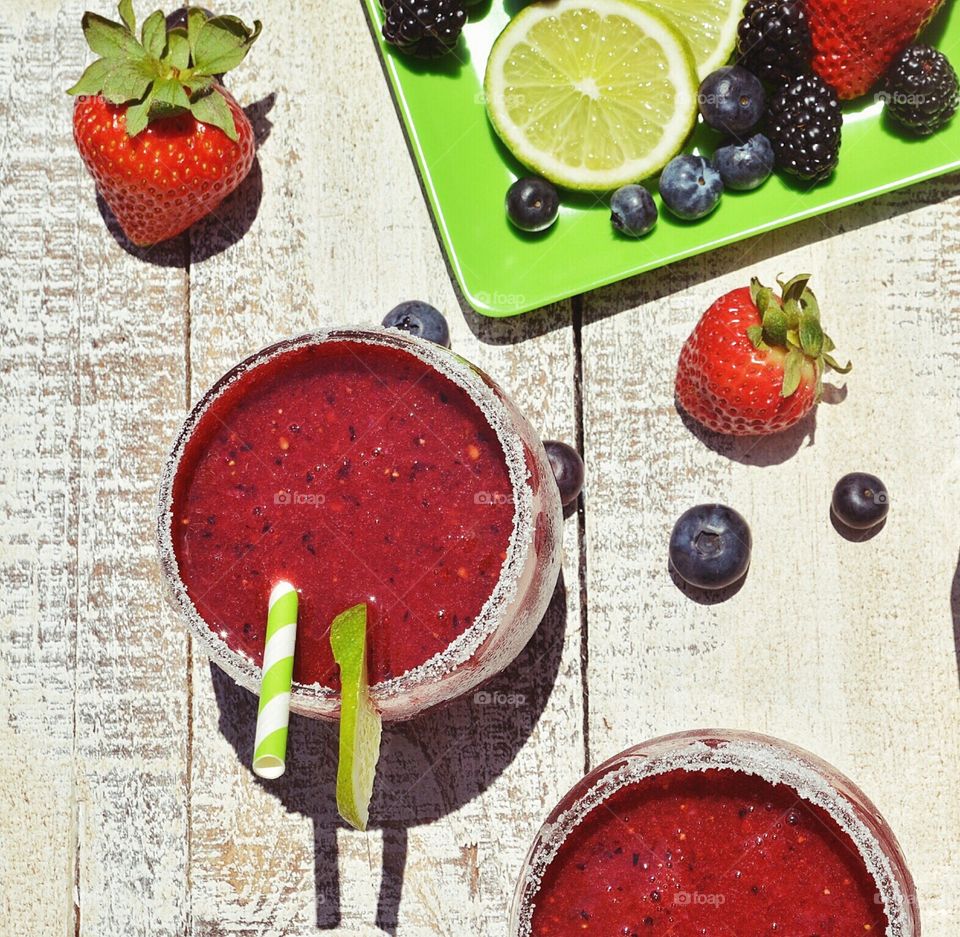 Strawberry smoothies on wood with various berries