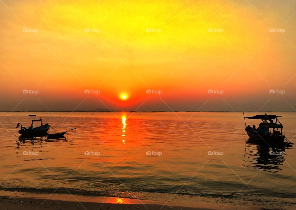 Beauiful sunset and gold shade sky with  silhouette two fisherman on the sea