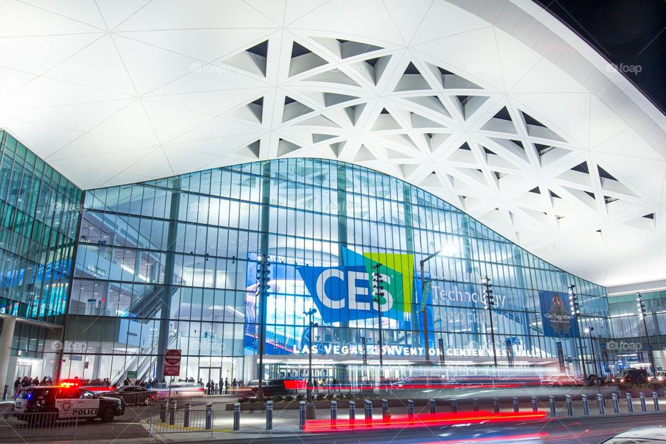 Las Vegas, NV, USA 1-6-2023: Exterior of Convention Center West Hall during CES2023. Logo of CES on glass wall. Light trails from car headlights of traffic passing by. Captured in long exposure.