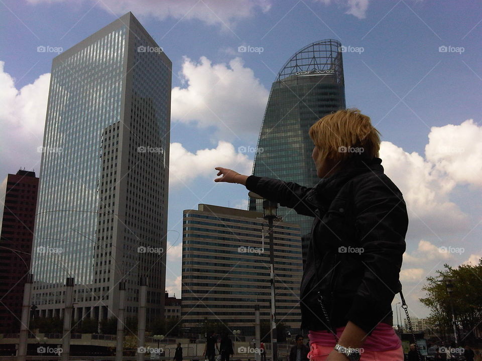 They are three giant buildings. They are in Paris near a shopping center. To be more or less at the height of the buildings, the model has climbed on top of a platform.