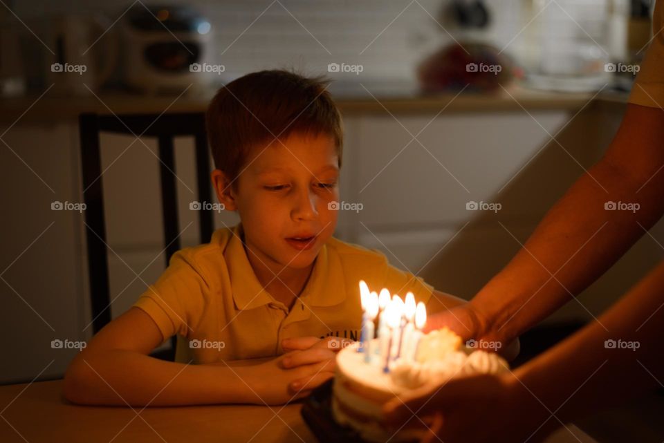 child boy blowing candles on birthday cake