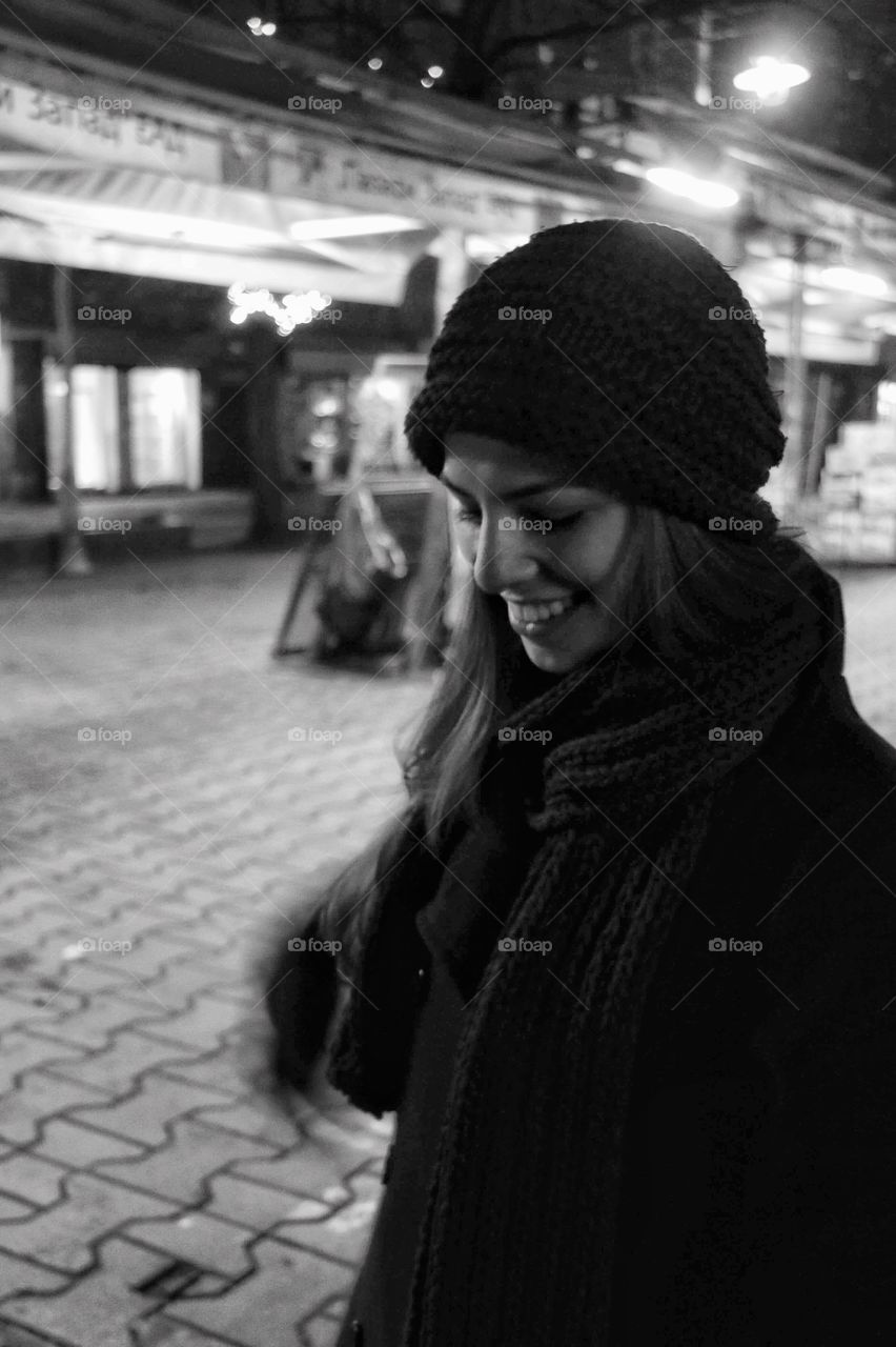 Black and white photo of a girl, who is cold and wears a winter clothes 