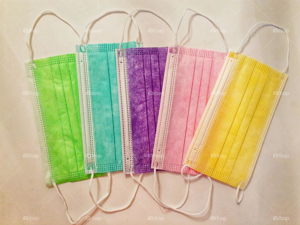 Five different disposable face masks, each a different color that one can wear to help protect them.