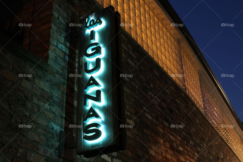 The neon light of a city cocktail bar and restaurant called Las Iguanas.