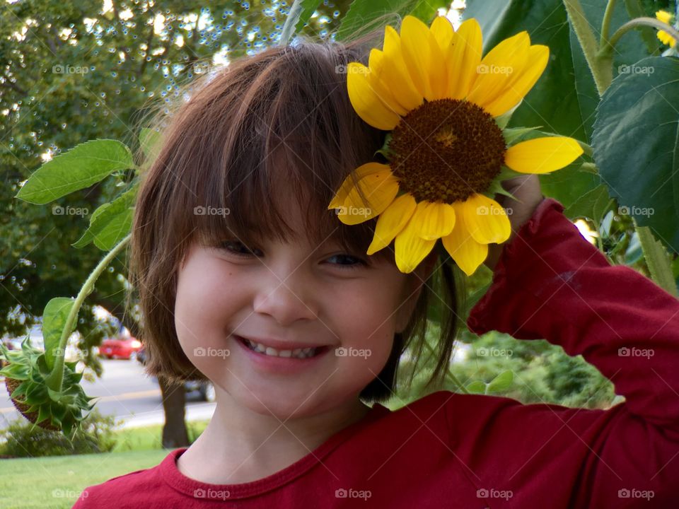 Cute girl holding yellow flower in hand