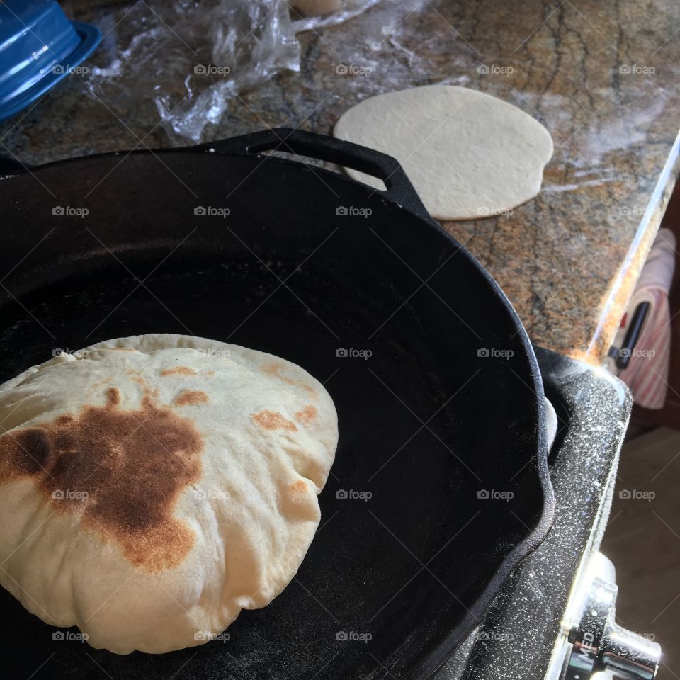 Homemade, from scratch pita bread. The smell of the freshly risen dough and the yeast helping the dough rise higher and higher. Then pant fried to perfection. 