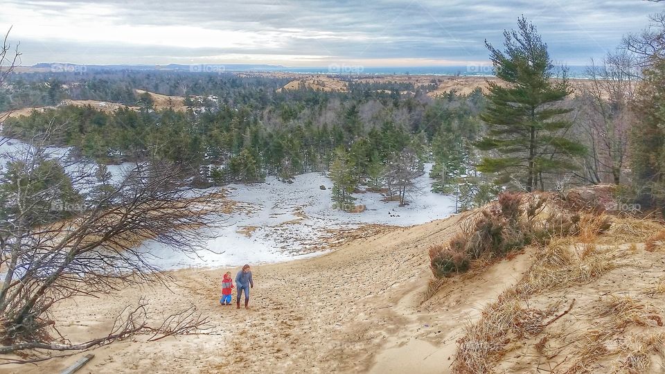 hiking up sand dune before snow melts