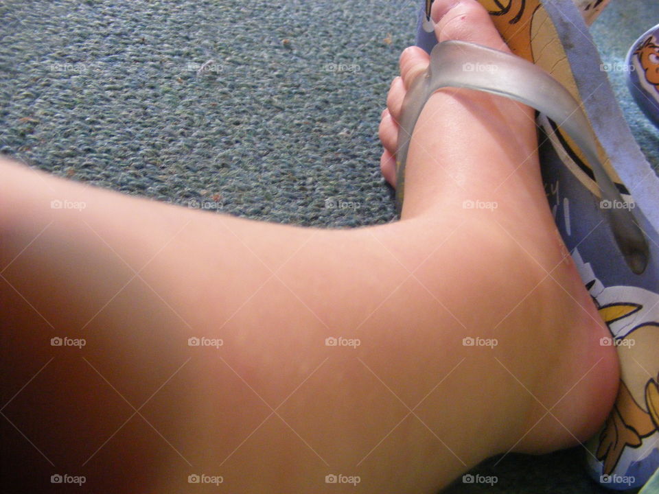 This little boys leg and his foot will walk many miles in his life time. His toes will wiggle and he wears small rubber jandal. It will grow very big one day. It is resting now.