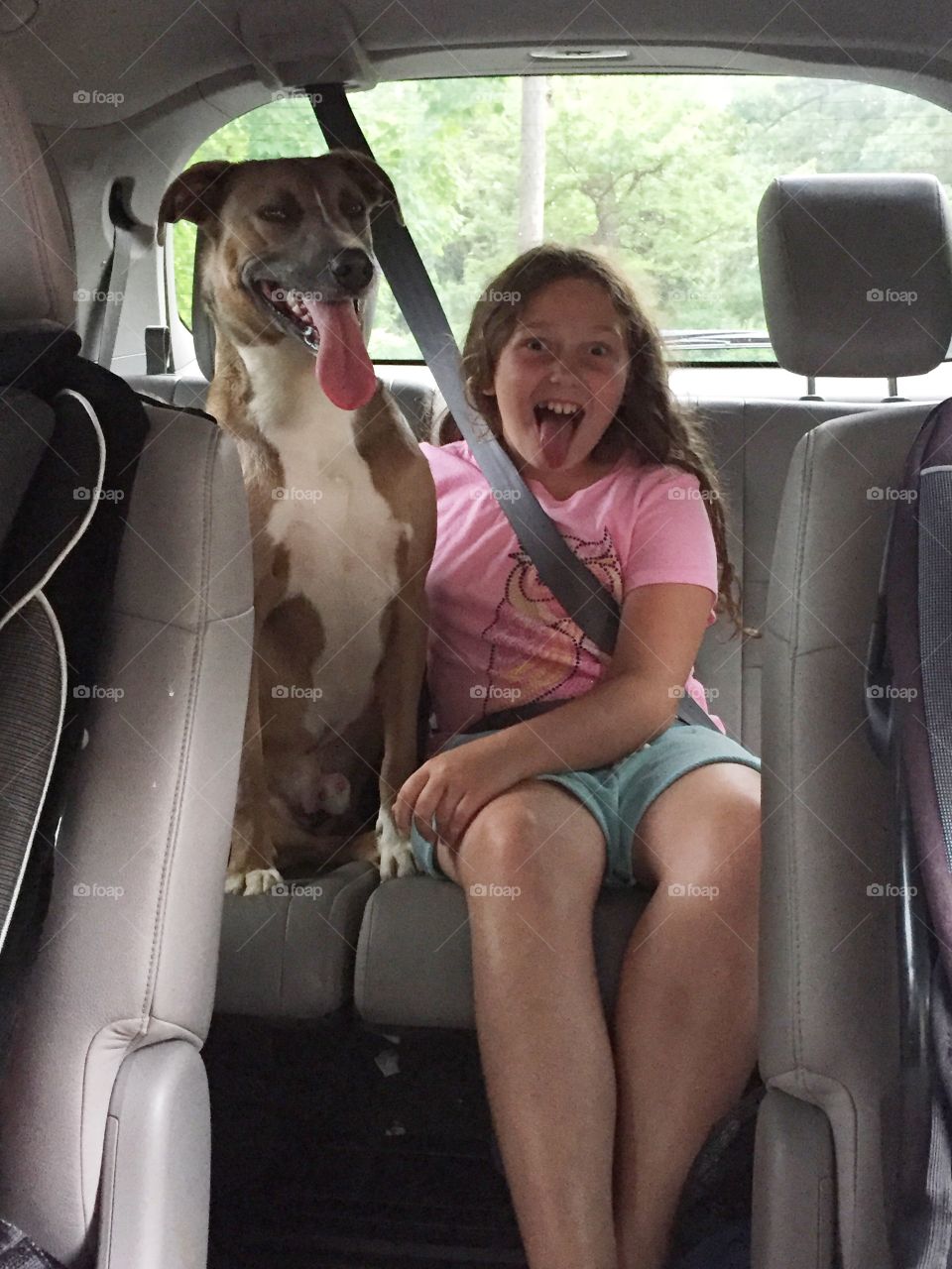 Girl with her dog in car