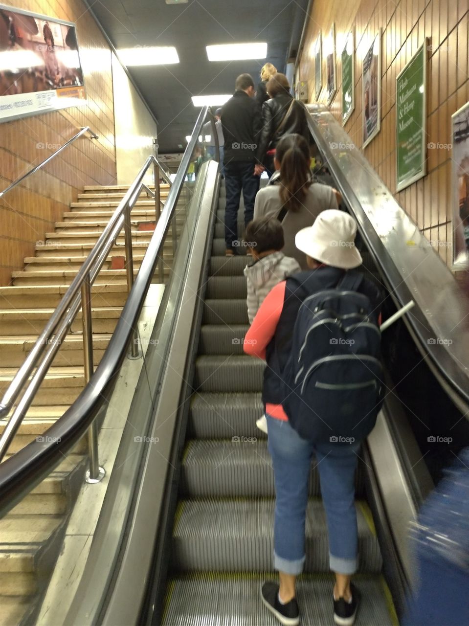 Gente subiendo por la escalera mecánica en el metro