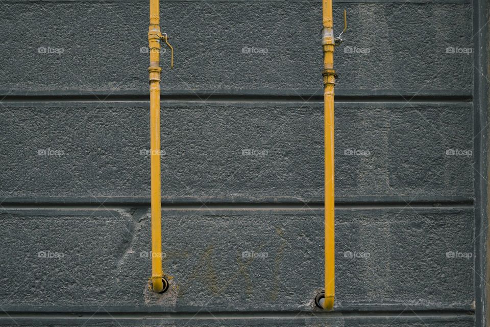 Yellow gas pipes on concrete wall.  minimalism concept
