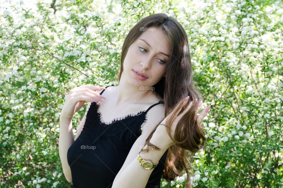 Portrait of a woman brunette on background of flowers