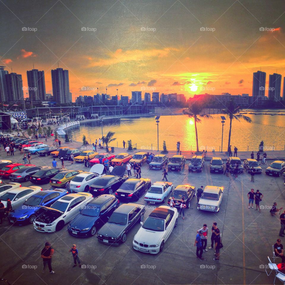 drone aerial view from above of bmw cars parked next to a lake