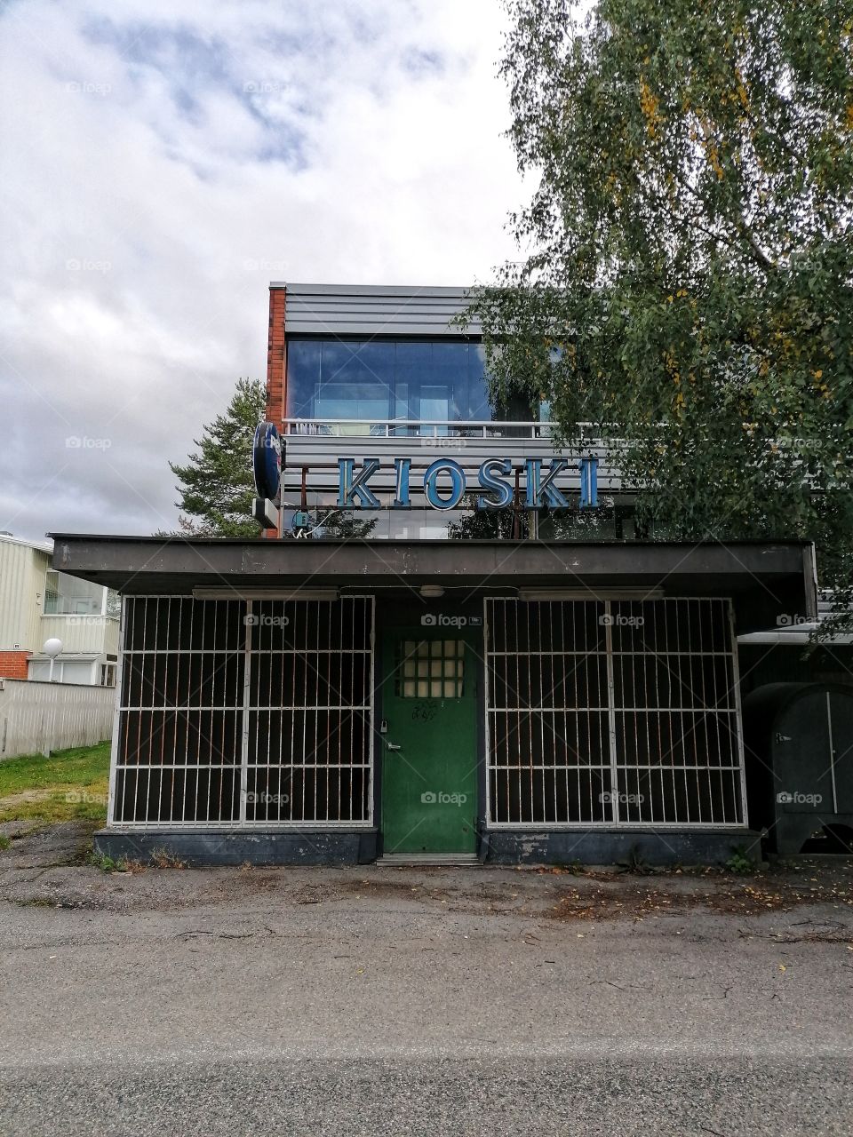 An old dilapidated building in the middle of a town that used to be a shop. No one walks through this door anymore. Sad.