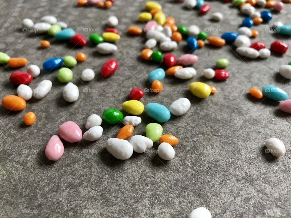 A lot of small round sweets in grey background 