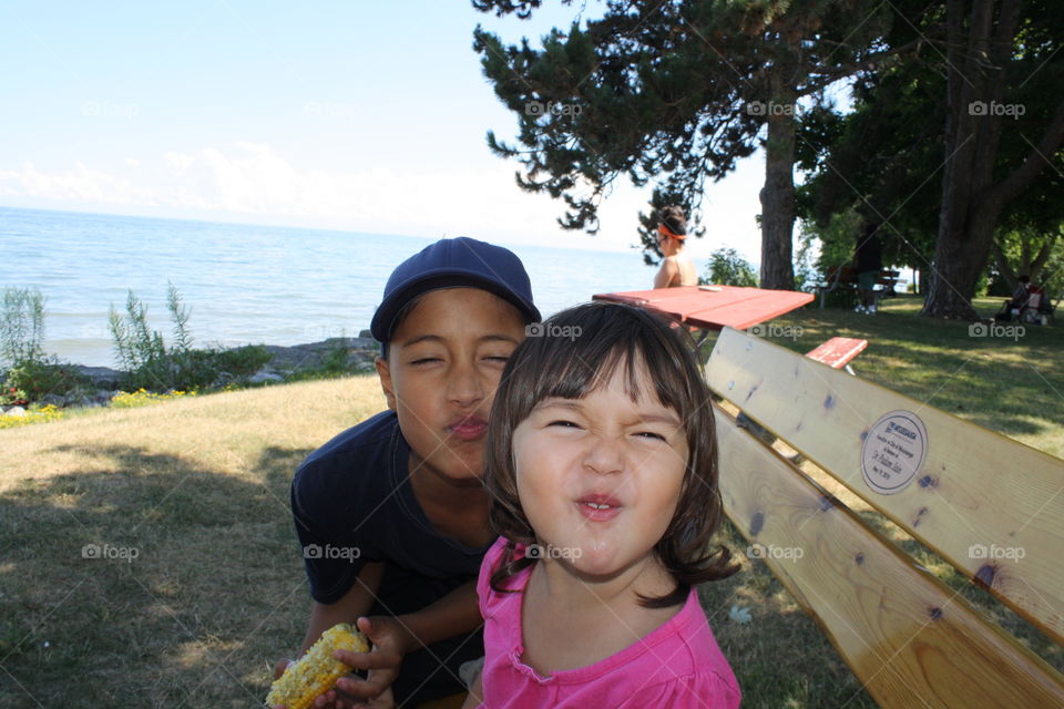 Brother and sister with funny face at park near sea