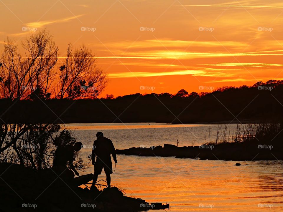 Silhouette of men on the bay shoreline!   The sunset was a perfect conclusion of the day. It was silky, and a smooth collusion of sky burst of yellows and orange