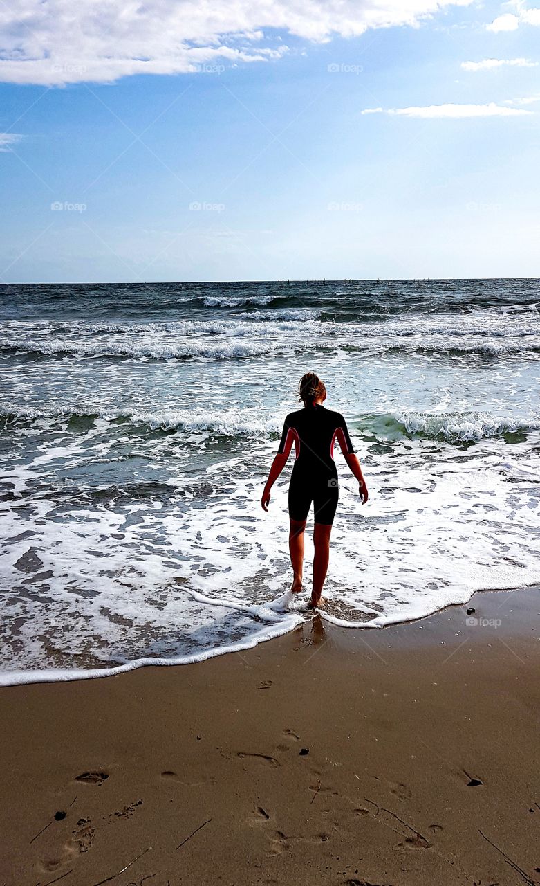 at the beach - a girl goes into the water