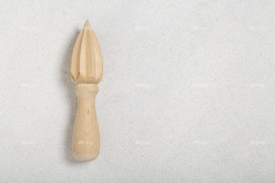 wooden orange juicer on marble background