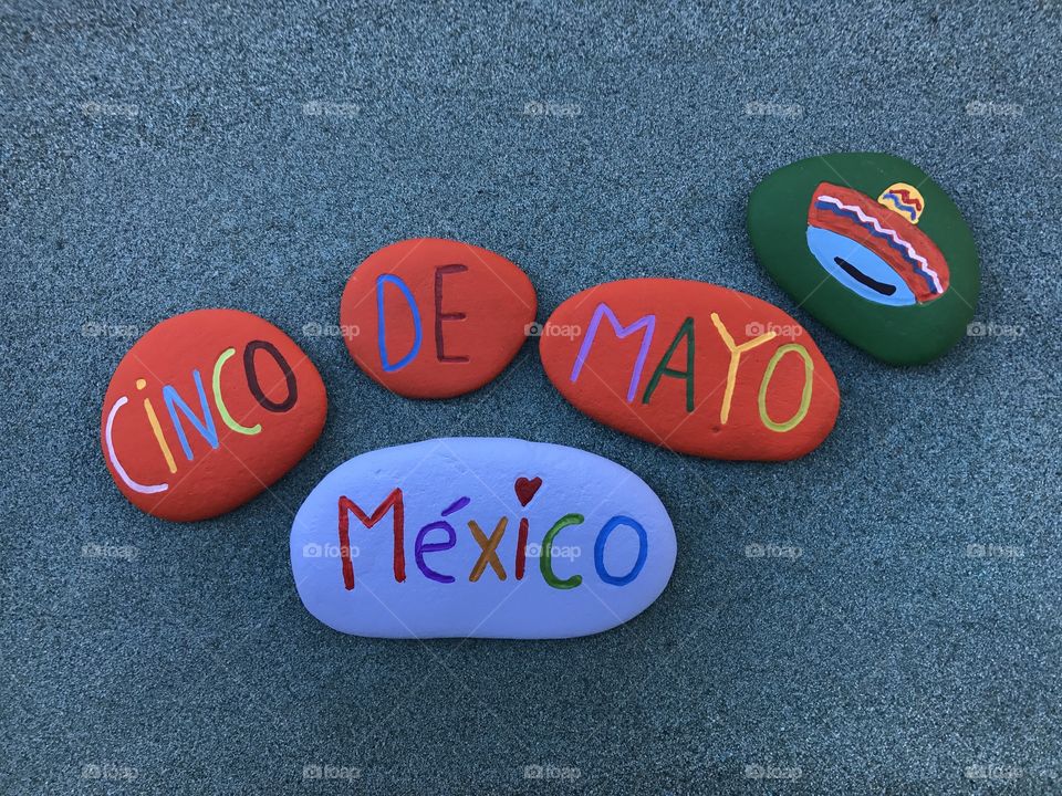 Cinco de Mayo, famous mexican holiday, souvenir with painted stones over green sand 