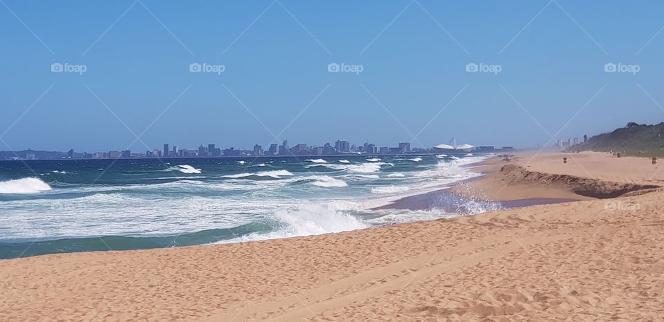 Deserted beach on a hot summer's day in Umhlanga with a view of Durban in the distance