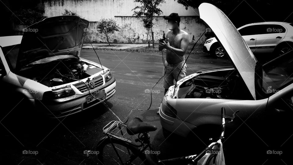Ignição, cabos, e conectores em dois carros para interligar as baterias para a partida.