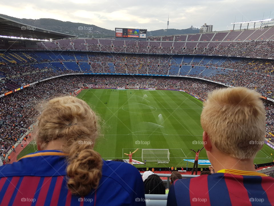 sister and brother watching a barcelona match campnou spain stadium football