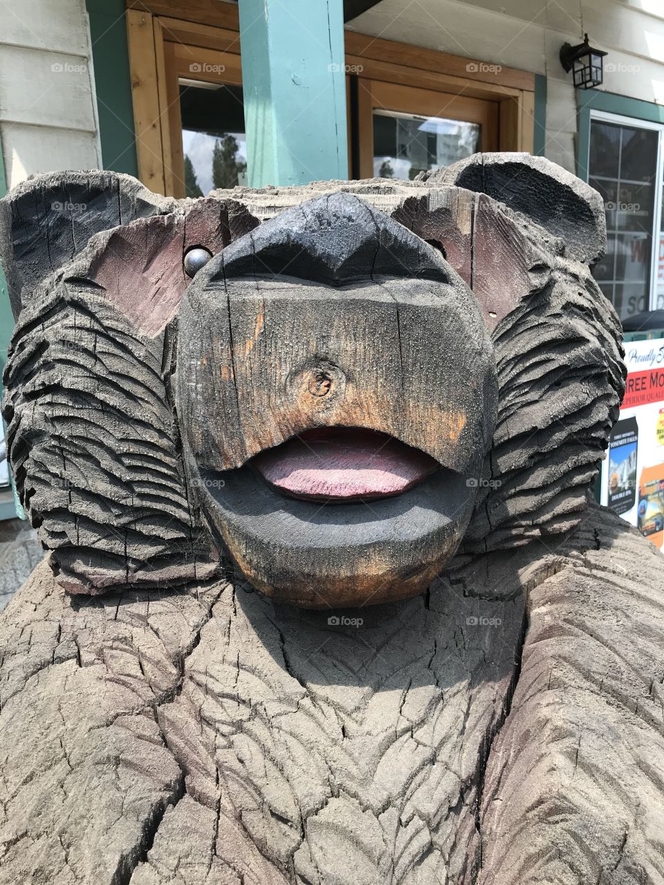 A wooden bear standing there to guard the deli and coffee shop around the clock. This is a good close-up view of him. It is getting up close and personal. 😀