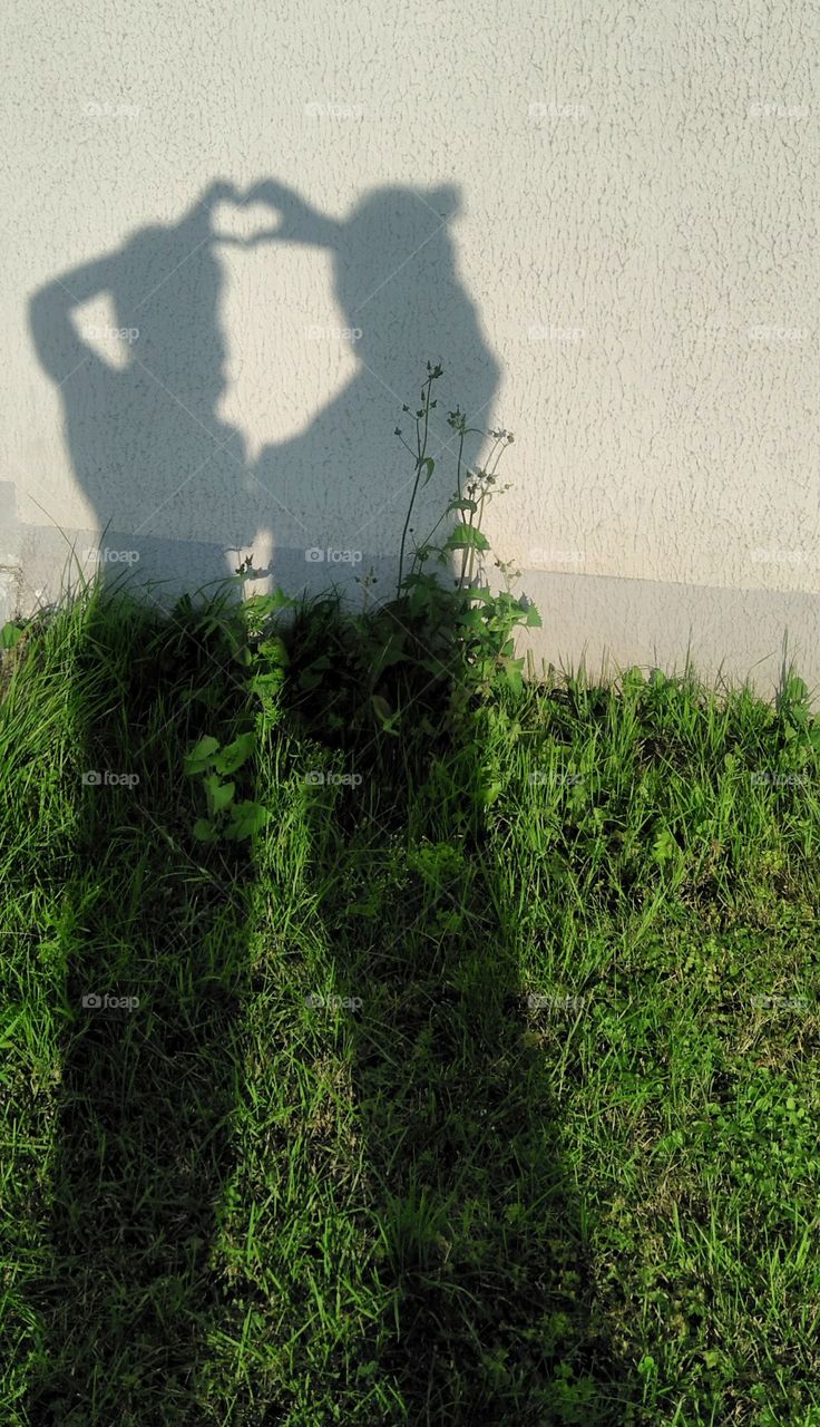 shadows woman's family on a green grass and wall background, mother and daughter, mother's day