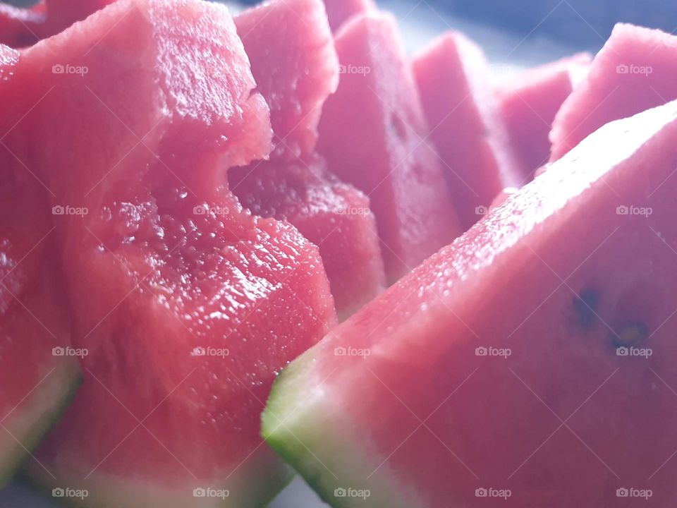 a close up portrait of slices of watermelon. the healthy fruit is ready to be eaten.