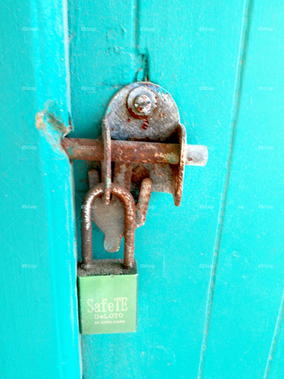 Turquoise door with rusted lock