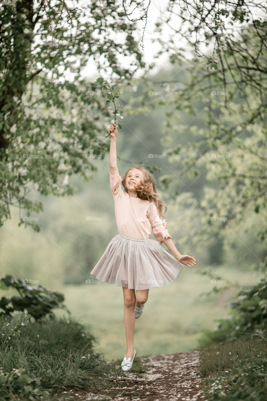 Girl in blossom garden at rainy day