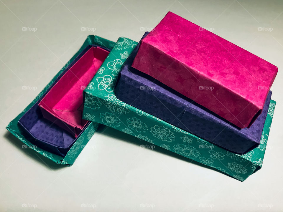 Here are some little hand-made origami rectangular nesting boxes constructed in colourful, patterned paper in shades of pink, purple & turquoise.