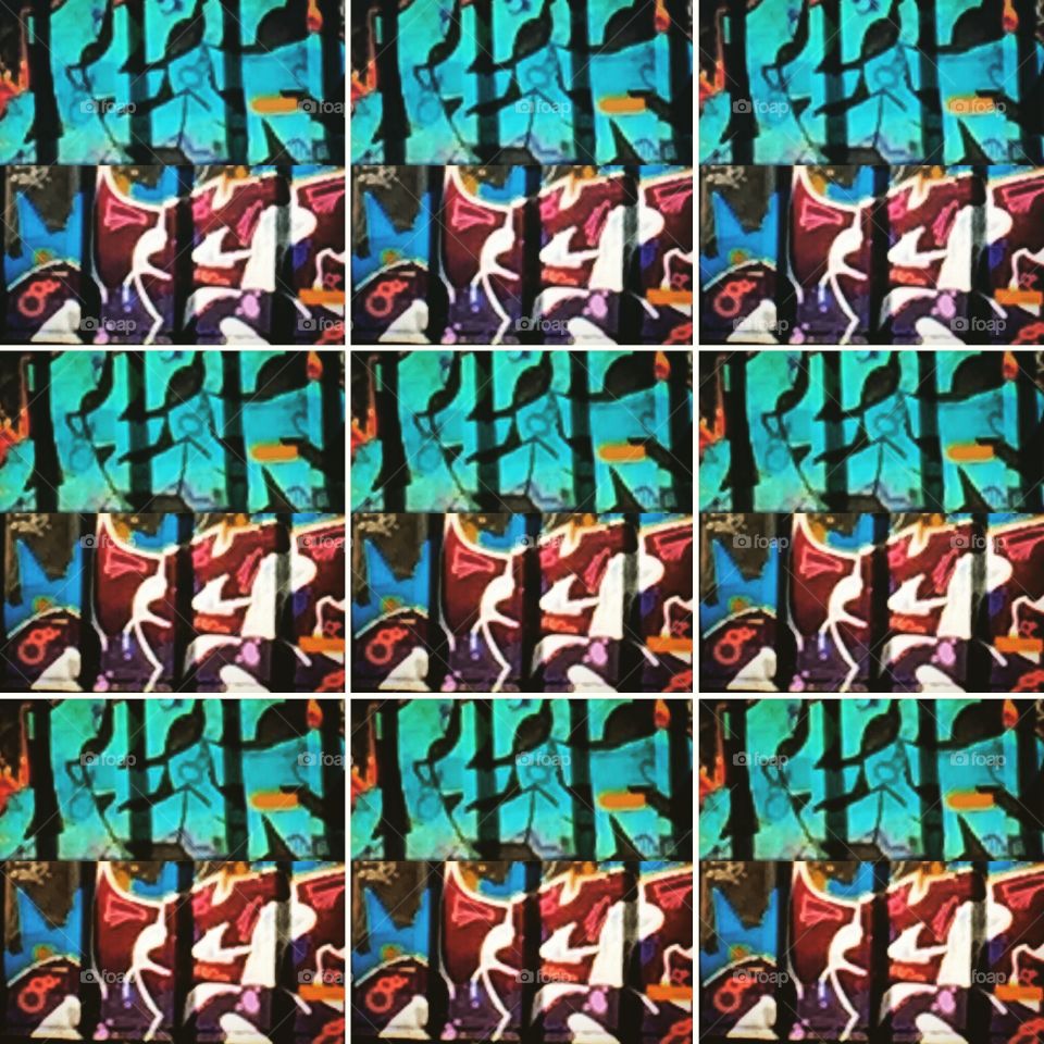 Repeating design of brightly colored graffiti art on a wall