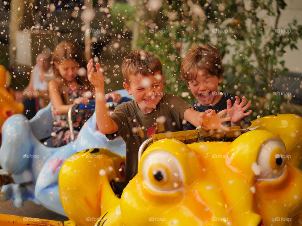 Cute friends riding in amusement park