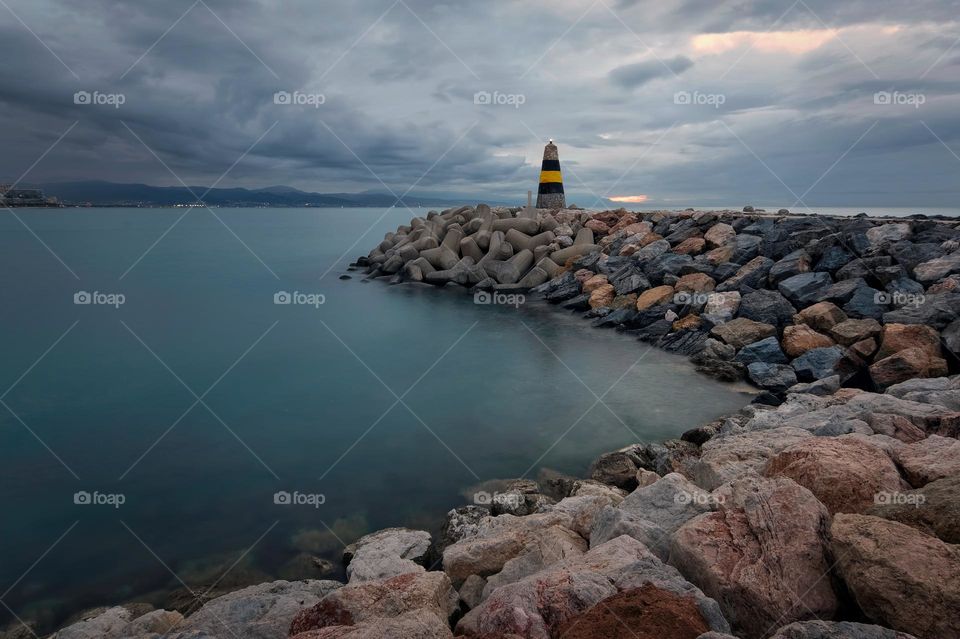 Dramatic cloudy morning scenery of lighthouse at Banalmadena, Malaga, Spain