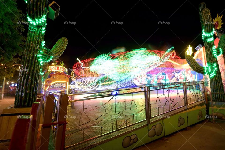Fun at the Prater in Vienna. Neon lighted carousel rotating in the dark