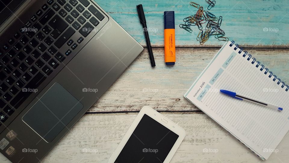 Desk with laptop, tablet and diary