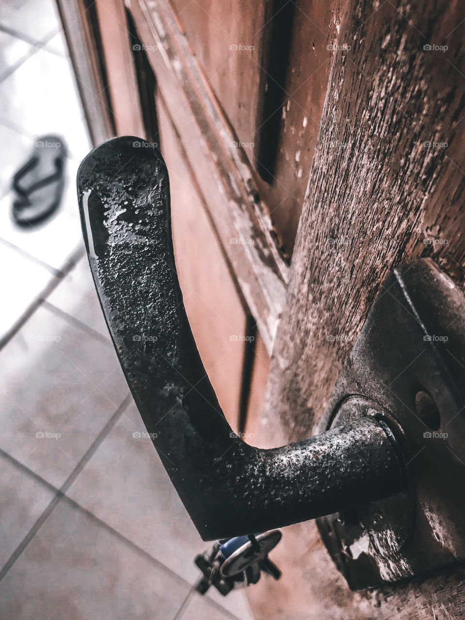 Wet rustic door handle and and an old door wood itself.