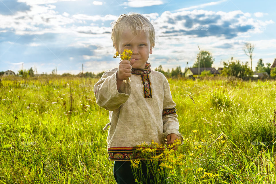 Blond boy in a folk shirt